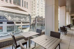 um restaurante com mesas e cadeiras e uma grande janela em Cambria Hotel Philadelphia Downtown Center City em Filadélfia