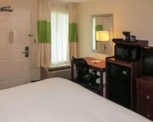 a hotel room with a bed and a desk with a television at Quality Inn Cranberry Township in Cranberry Township