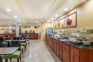 a restaurant with a buffet line with tables and chairs at Quality Inn & Suites Middletown - Newport in Middletown