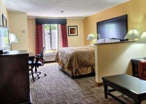 a hotel room with a bed and a desk at Quality Inn & Suites Greenville near downtown in Greenville