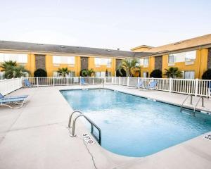 a pool at a hotel with chairs and a building at Sleep Inn near Outlets in Myrtle Beach