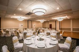 a room filled with tables and chairs with white linens at Quality Inn Sumter in Sumter