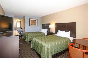 a hotel room with two beds and a flat screen tv at Quality Inn Clinton - Laurens I-26 in Clinton