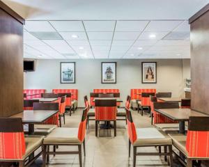 a dining room with tables and chairs and red chairs at Comfort Suites at Isle of Palms Connector in Charleston