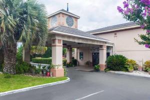 a building with a palm tree in front of it at Quality Inn Goose Creek - Charleston in Charleston