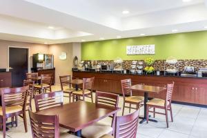 a restaurant with wooden tables and chairs and a counter at Sleep Inn Charleston - West Ashley in Charleston