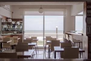 un restaurante con mesas y sillas y una gran ventana en MitreCity en Ostende