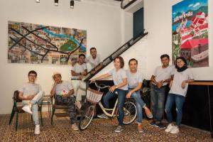 a group of people posing for a picture with a bike at The Brownstone Hostel & Space in Ipoh