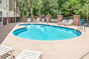 a large swimming pool with chairs at Comfort Suites Bluffton-Hilton Head Island in Bluffton