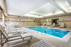 a pool with chaise lounge chairs and a swimming pool at Comfort Suites Clinton near Presbyterian College in Clinton