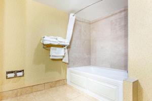 a bathroom with a white bath tub and towels at Comfort Suites Clinton in Clinton