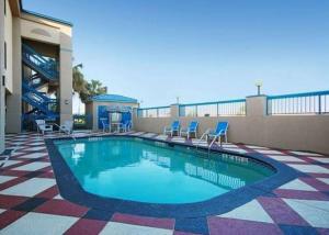 a swimming pool on top of a building with chairs at Quality Inn & Suites Ft Jackson Maingate in Columbia