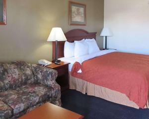 een hotelkamer met een bed en een bank bij Rodeway Inn Walterboro I-95 in Walterboro