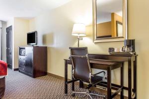 a hotel room with a desk and a chair at Comfort Suites Clinton near Presbyterian College in Clinton