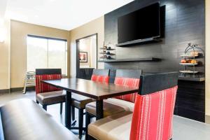 a dining room with a table and chairs and a television at Comfort Suites Clinton in Clinton