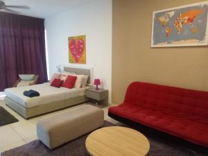 sala de estar con cama y sofá rojo en Bangi Studio Suite, en Kampong Sungai Ramal Dalam