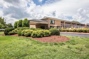 una casa con arbustos delante de un edificio en Rodeway Inn Expo Center en Spartanburg