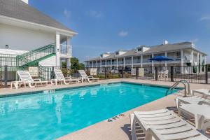 a swimming pool with lounge chairs and a building at Quality Inn in Cheraw