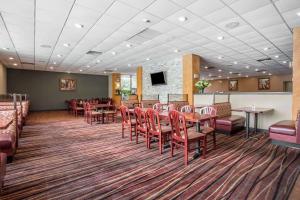 a waiting room with red chairs and tables at Clarion Hotel Fort Mill Near Amusement Park in Fort Mill