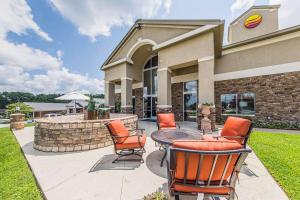a patio with chairs and a table in front of a building at Comfort Inn & Suites Greenwood near University in Greenwood