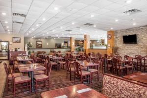 comedor con mesas y sillas de madera en Clarion Hotel Fort Mill Near Amusement Park, en Fort Mill