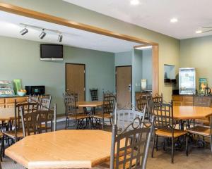 a dining room with tables and chairs and a tv at Quality Inn Brookings-University in Brookings
