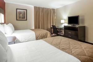 a hotel room with two beds and a flat screen tv at Clarion Hotel Fort Mill Near Amusement Park in Fort Mill