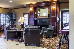 a living room with a fireplace and chairs and a mirror at Quality Inn & Suites Airport North in Sioux Falls