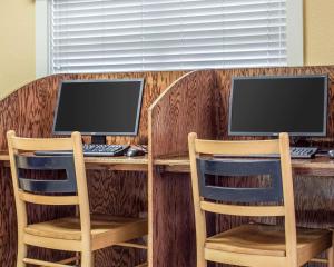 dois monitores de computador sentados numa secretária com duas cadeiras em Bluegreen Vacations Harbour Lights em Myrtle Beach