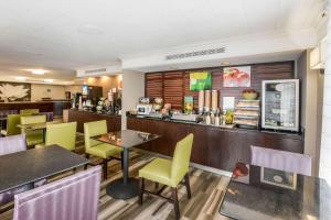 a restaurant with yellow chairs and a bar at Quality Inn & Suites North Charleston - Ashley Phosphate in Charleston