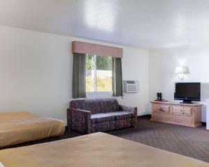 a hotel room with a bed and a couch and a tv at Royal Inn Keystone in Keystone