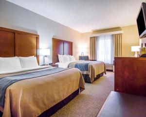 a hotel room with two beds and a flat screen tv at Comfort Inn & Suites Hotel in the Black Hills in Deadwood