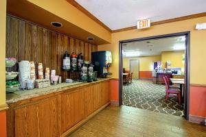 un vestíbulo de un hotel con una barra con botellas de vino en Quality Inn Huron, en Huron