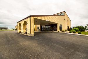 a large yellow building with a parking lot at Econo Lodge Watertown in Watertown