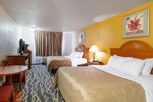 a hotel room with two beds and a television at Quality Inn Huron in Huron