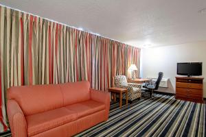 a living room with a couch and a desk and a television at Quality Inn Huron in Huron