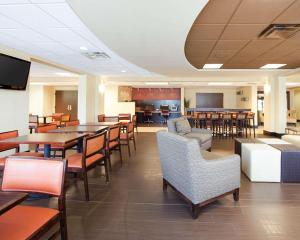 a dining room with tables and chairs and a cafeteria at Comfort Inn Oak Ridge in Oak Ridge