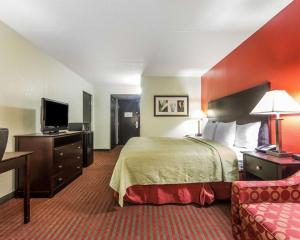 a hotel room with a bed and a flat screen tv at Quality Inn West - Sweetwater in Sweetwater