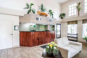 een woonkamer met een bank en planten aan de muur bij Quality Inn Savannah South in Savannah