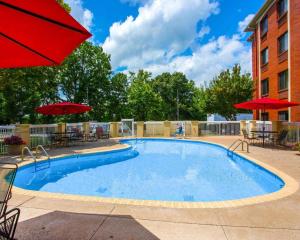 een groot zwembad met tafels, stoelen en parasols bij Sleep Inn Nashville - Brentwood - Cool Springs in Brentwood