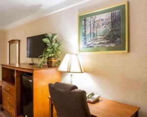 Habitación de hotel con silla y escritorio con teléfono. en Econo Lodge North, en Knoxville