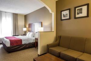 a hotel room with a bed and a couch at Quality Suites in Morristown
