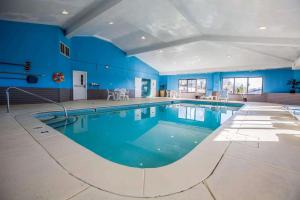 a large swimming pool in a large room with blue walls at Quality Suites in Morristown