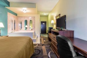 a hotel room with a bed and a flat screen tv at Quality Inn & Suites Memphis East in Memphis