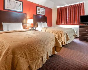 2 camas en una habitación de hotel con paredes de color naranja en MainStay Suites Knoxville Airport en Alcoa