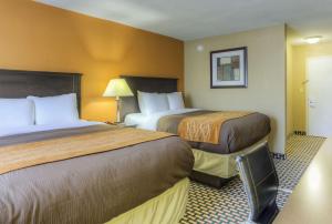 A bed or beds in a room at Quality Inn & Suites