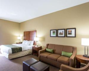 a hotel room with a bed and a couch at Comfort Suites Crossville in Crossville