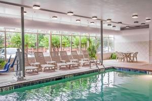 a pool with chairs and a table and a swimming pool at Quality Inn & Suites Germantown North in Memphis