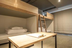 箱根WPÜ HOTEL HAKONE的客房设有一张桌子和一张双层床。