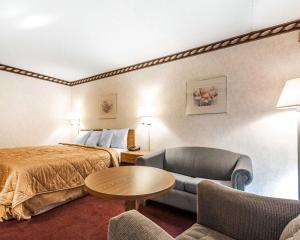 Habitación de hotel con cama, mesa y sillas en Rodeway Inn, en Sweetwater